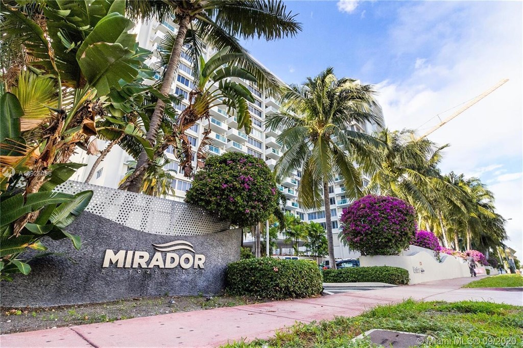 A building with the name "MIRADOR" on it is surrounded by palm trees.