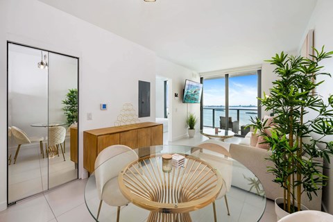 A modern dining room with a glass table and chairs.