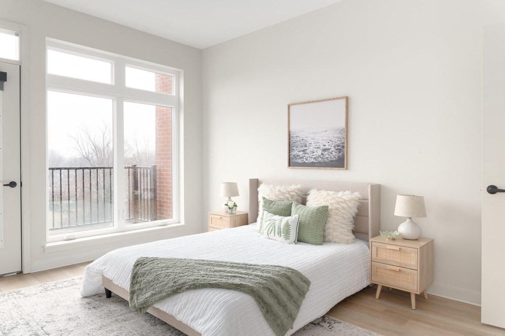 A bedroom with a large bed and a picture on the wall.