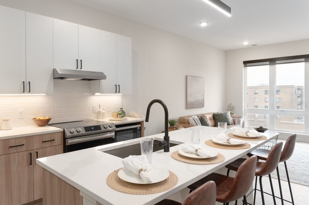A modern kitchen with a dining table set for two.