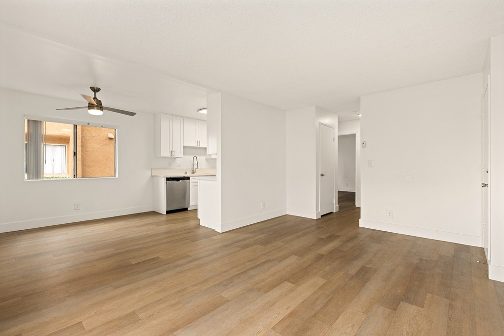 A room with a ceiling fan and wooden floors.