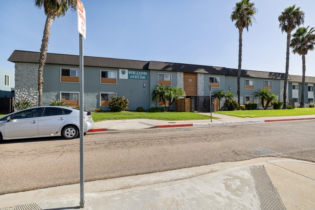 A street view of a building with a car parked in front.