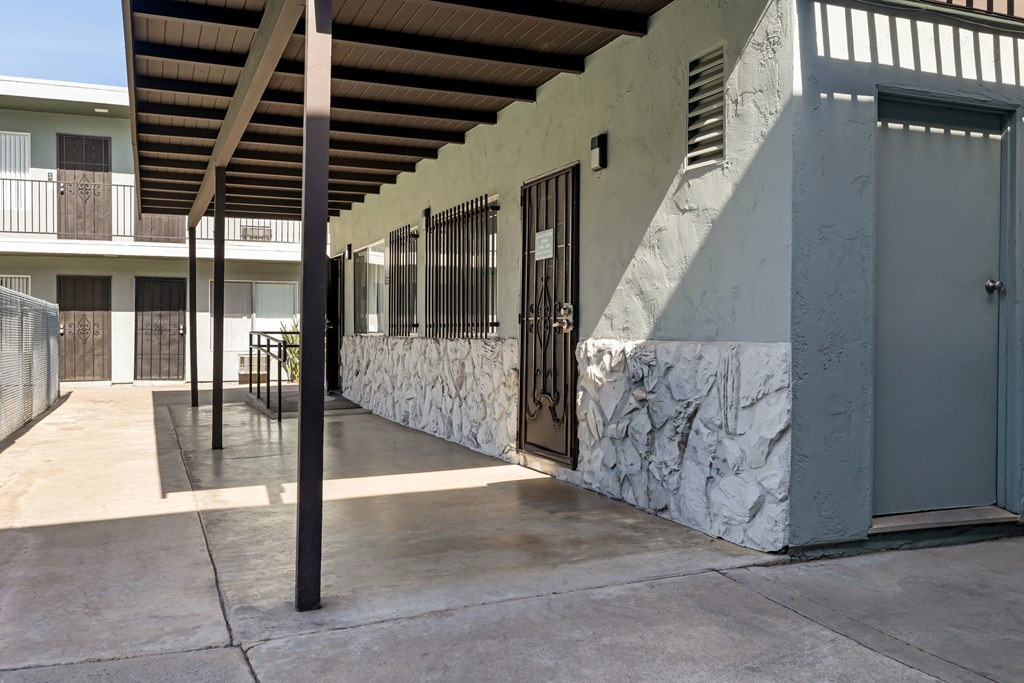 A building with a white marble wall and a black gate.