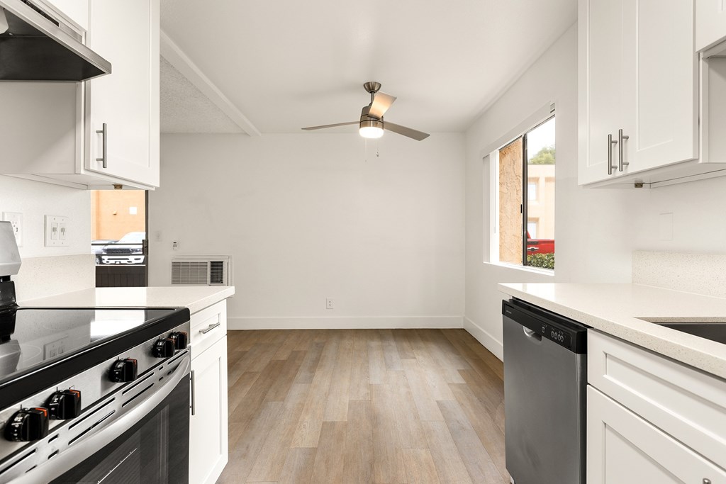A kitchen with a black stove top oven and white cabinets.