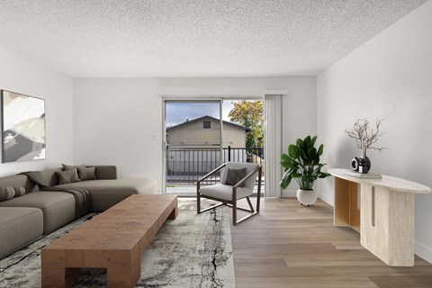 A living room with a grey couch, a wooden table, and a chair.