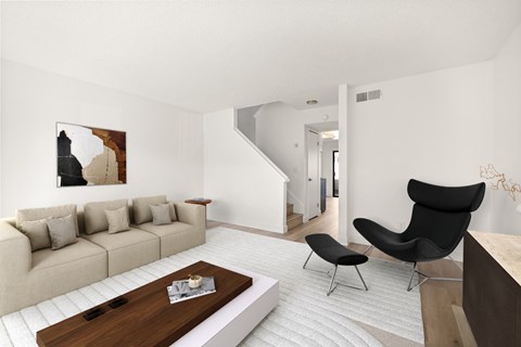 A living room with a beige sofa, a black chair, and a wooden coffee table.
