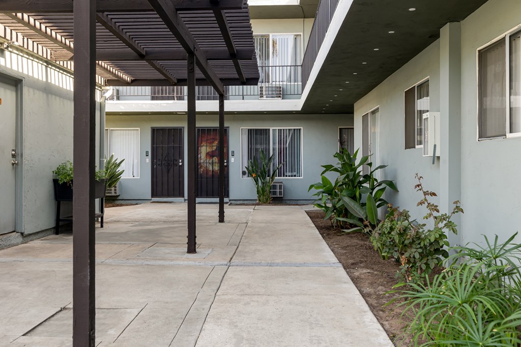 A patio with a black awning and a concrete floor.