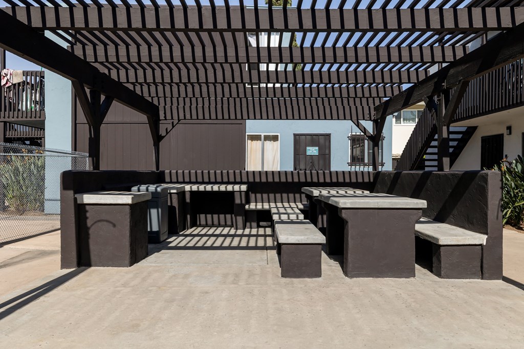 A modern outdoor seating area with a wooden pergola.