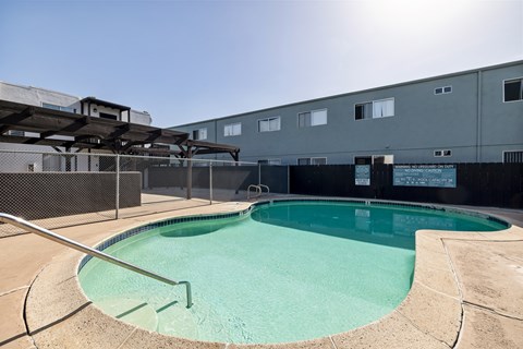 A small pool with a metal fence around it.
