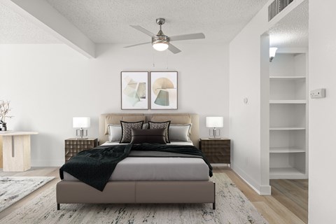 A bedroom with a large bed and a ceiling fan.