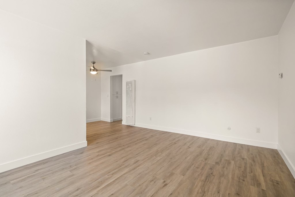 A room with wooden flooring and white walls.