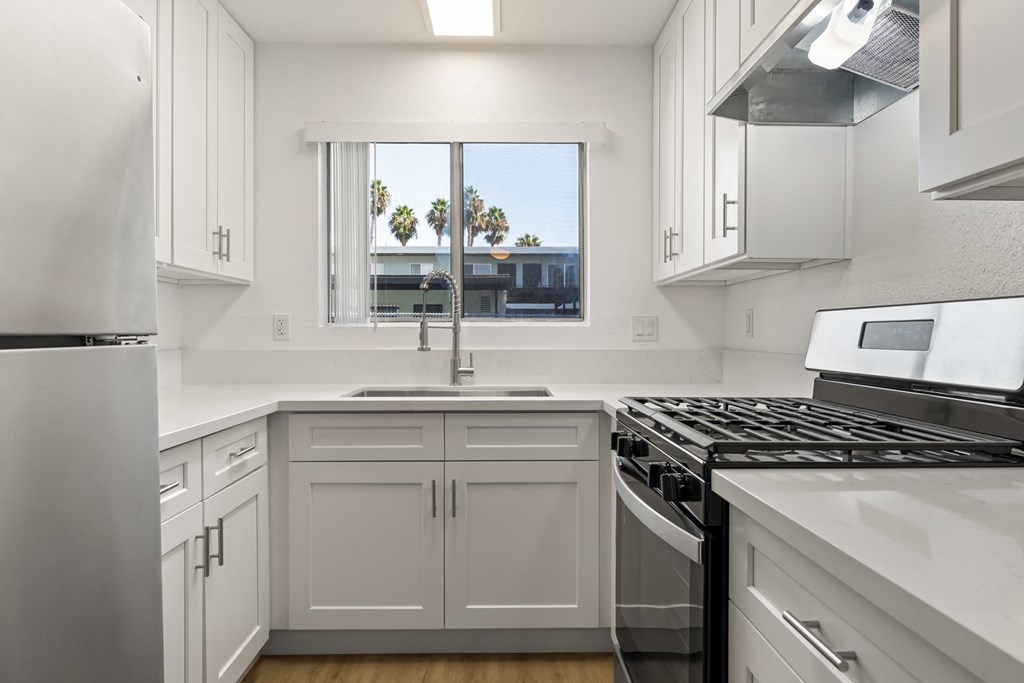 A kitchen with white appliances and cabinets.