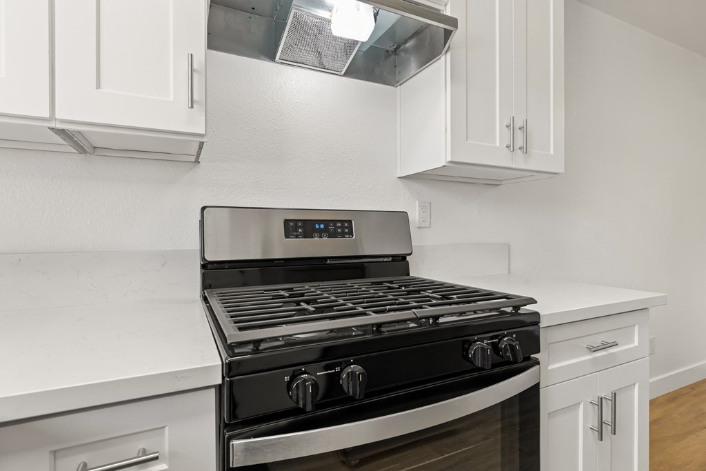 A modern kitchen with a black stove top oven.