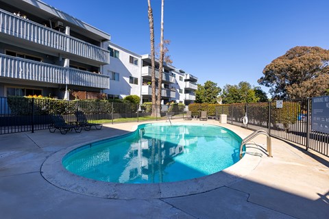 A swimming pool in a courtyard surrounded by buildings.