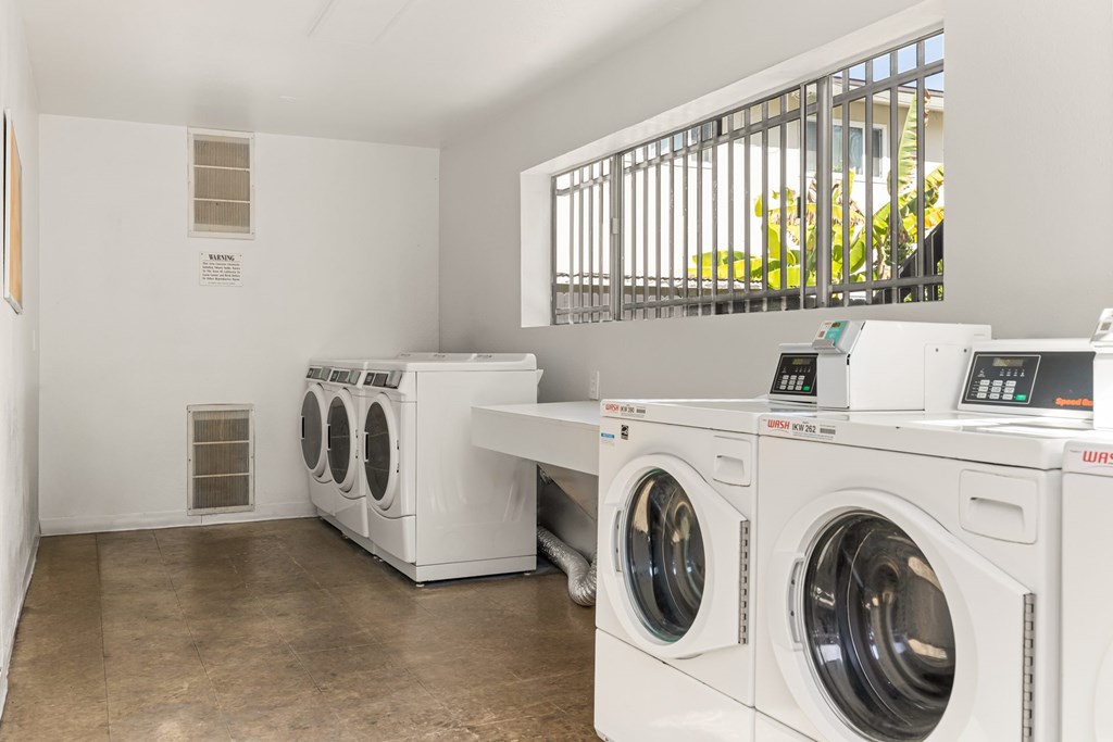 A row of front loading washing machines in a laundromat.