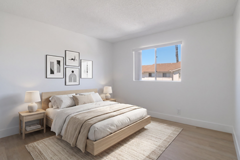 A bedroom with a large bed and a window overlooking a building.