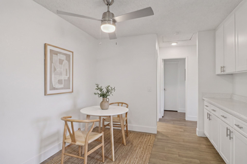 A dining room with a table and chairs.