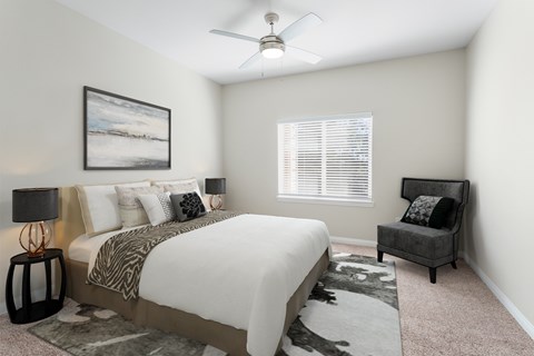 A bedroom with a large bed and a painting on the wall.