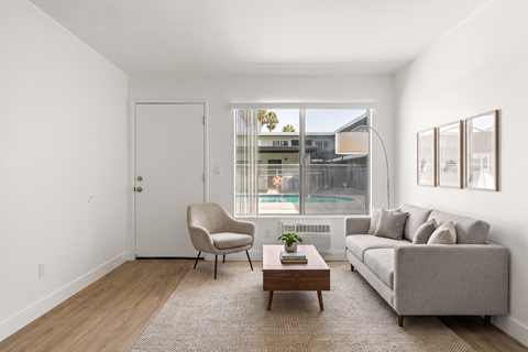 A living room with a grey couch, a chair, and a coffee table.