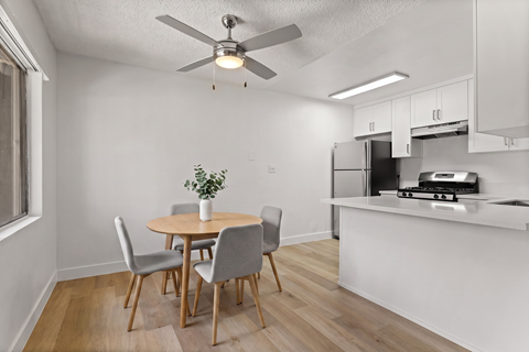 A dining room with a table and chairs.