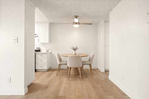 A dining room with a table and chairs.