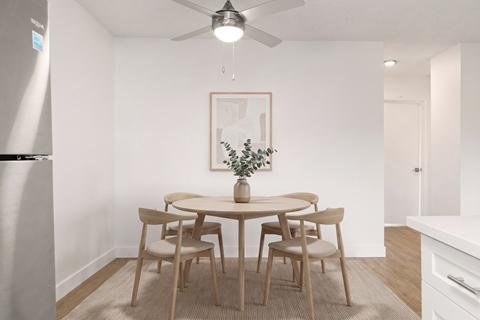 A dining room with a table and chairs.
