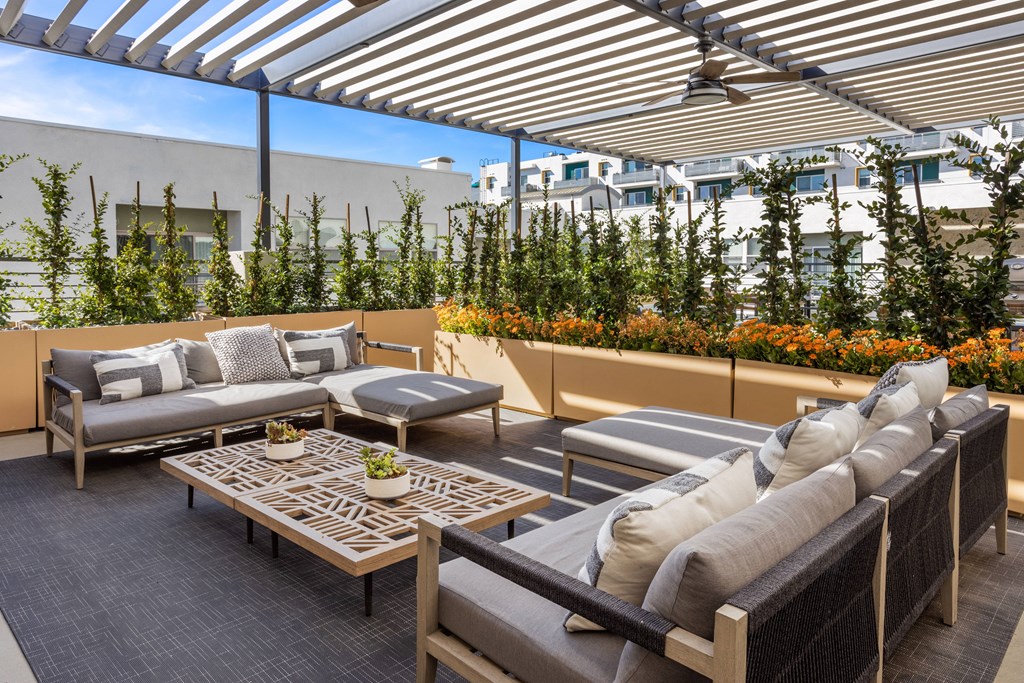 A patio with a table and chairs under a striped awning.