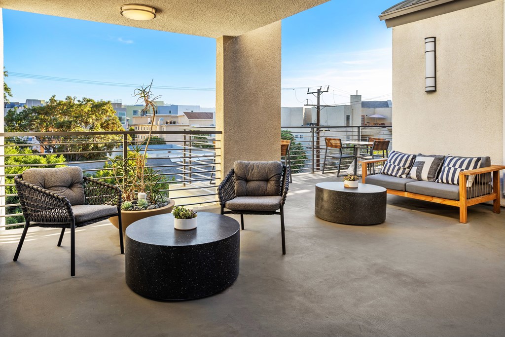A patio with a table and chairs overlooking a cityscape.