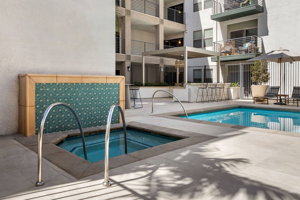A pool with a diving board in front of a building.