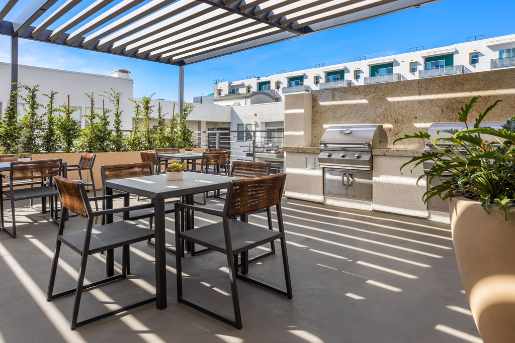 A patio with a table and chairs under a striped awning.