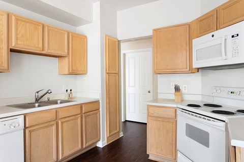 A kitchen with wooden cabinets and white appliances.