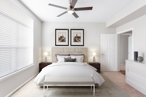 A bedroom with a large bed and two picture frames on the wall.