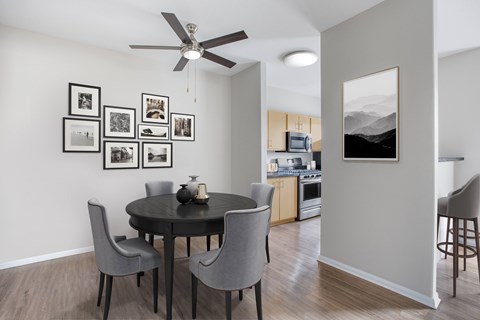 A dining room with a table and chairs and pictures on the wall.