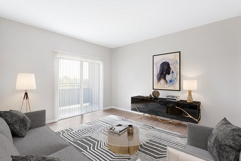 A living room with a grey couch, a coffee table, and a painting on the wall.
