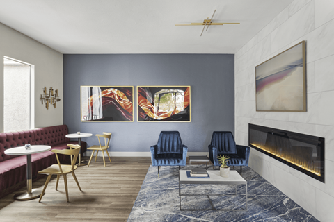 A living room with a fireplace and a painting on the wall.