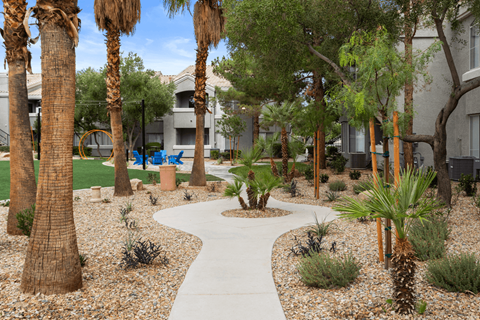 A pathway surrounded by palm trees and shrubs.