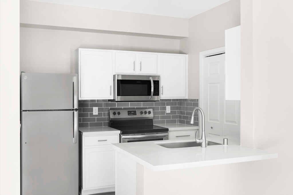 A kitchen with white appliances and cabinets.
