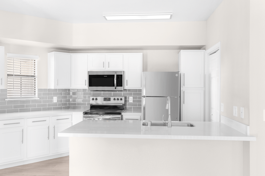 A modern kitchen with a stove, oven, and refrigerator.