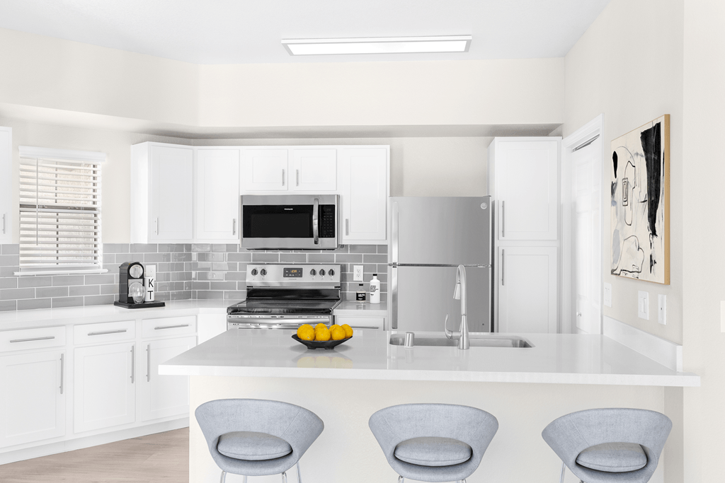 A modern kitchen with white cabinets and a central island.