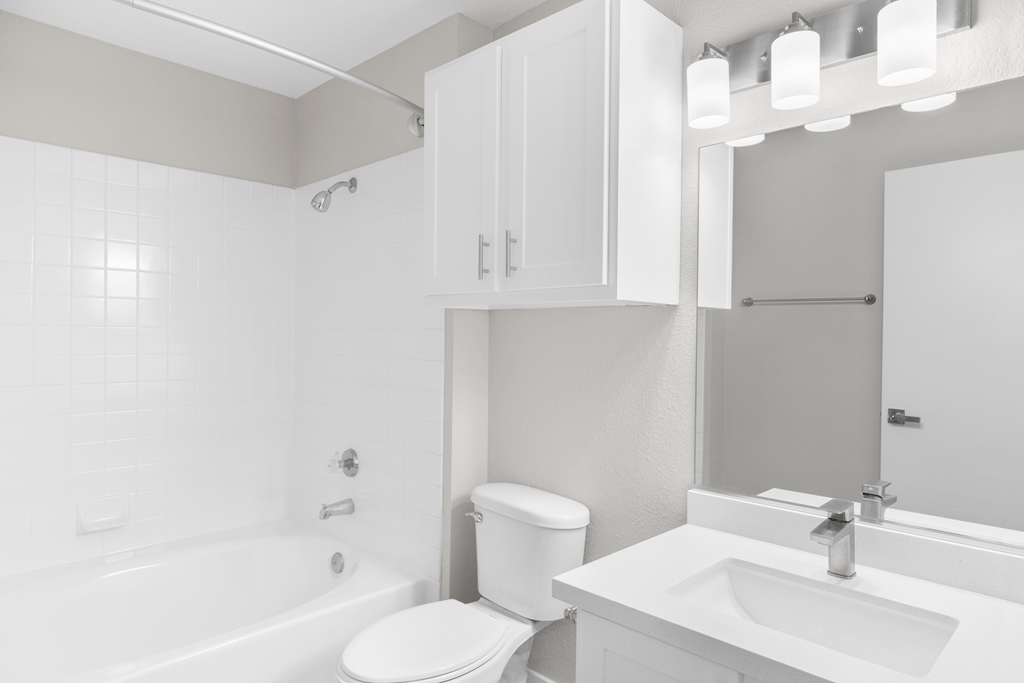 A white bathroom with a toilet, sink, and bathtub.