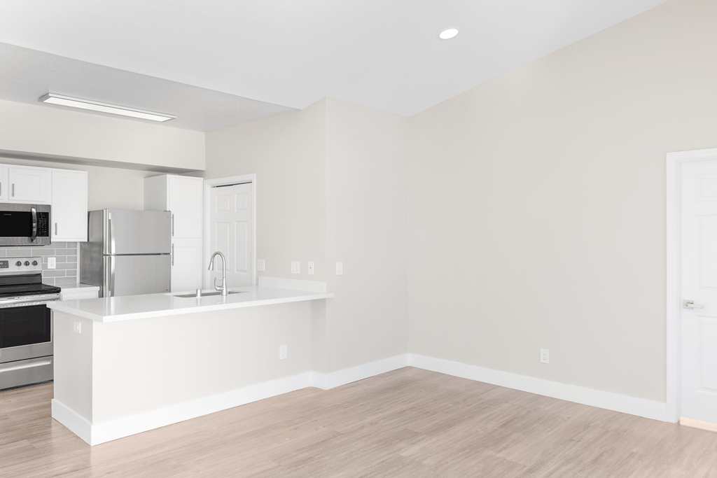 A kitchen with white appliances and cabinets.