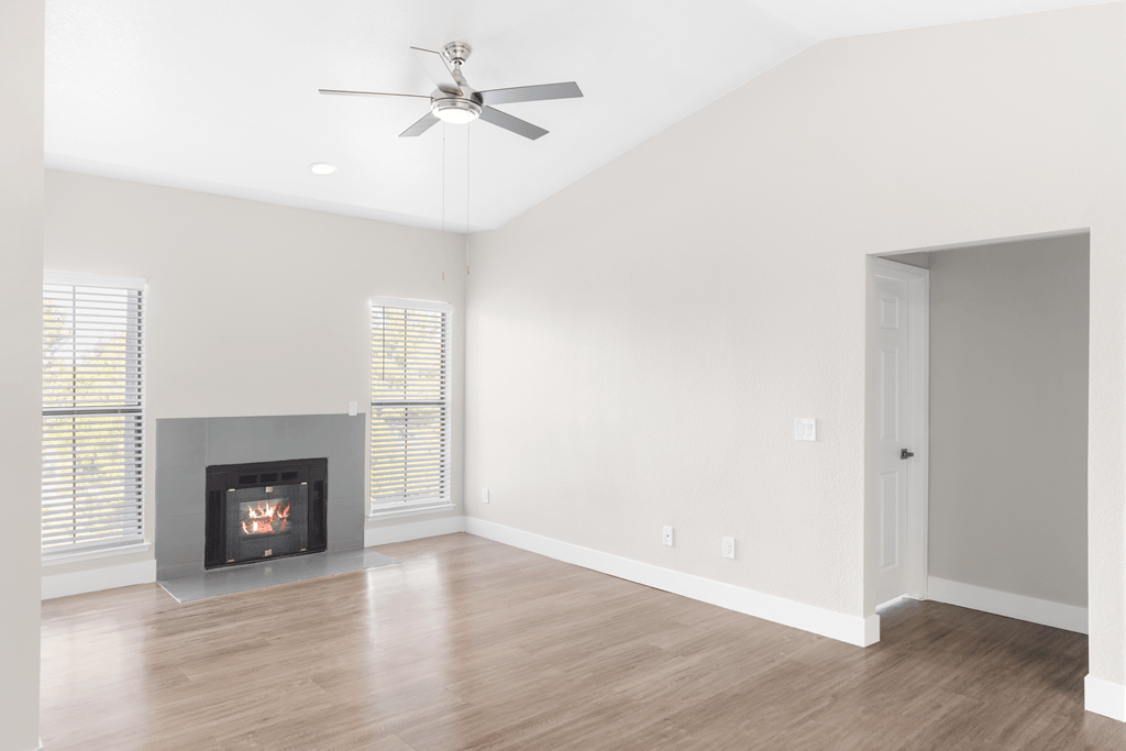 A room with a fireplace and a ceiling fan.
