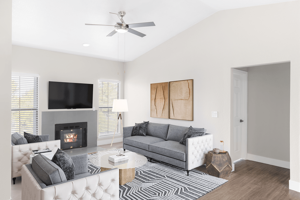 A living room with a fireplace, a grey couch, and a coffee table.