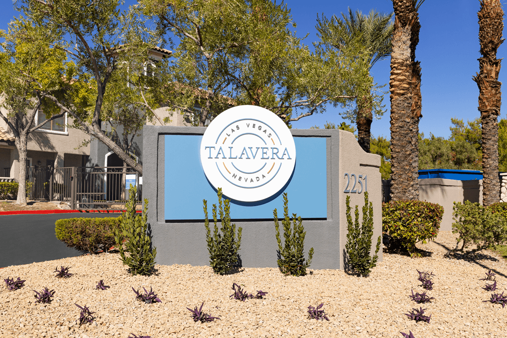 A sign for Talvera Neighborhood in front of a building.