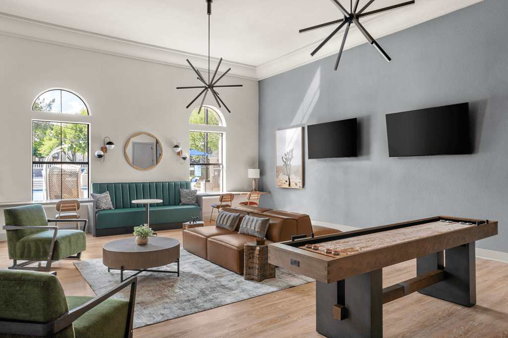A room with a pool table and a green couch.