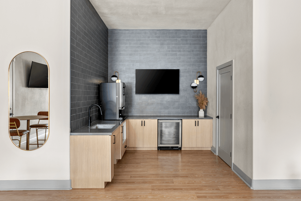 A modern kitchen with wooden cabinets and a grey backsplash.
