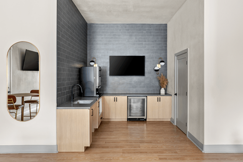 A modern kitchen with wooden cabinets and a grey backsplash.