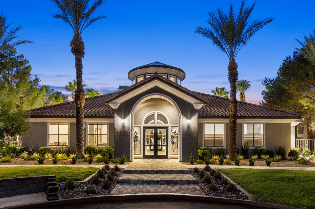 A modern house with a curved roof and a front yard with palm trees.