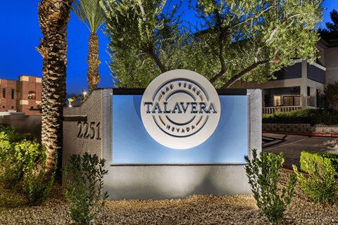 A sign for Talavera Village in Nevada is shown at dusk.