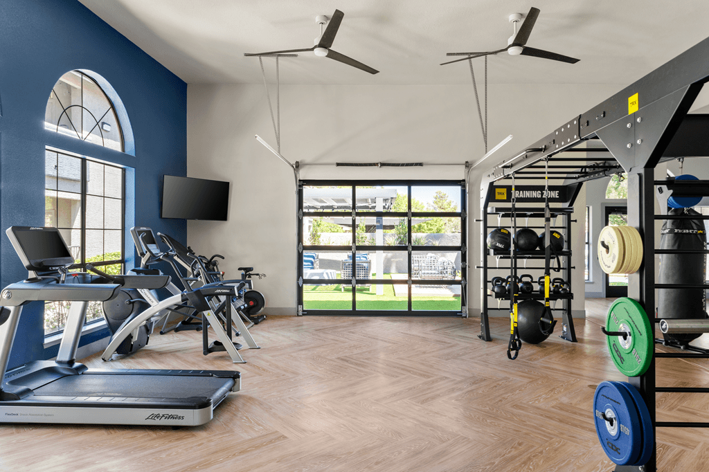 A gym with treadmills, weights, and exercise equipment.